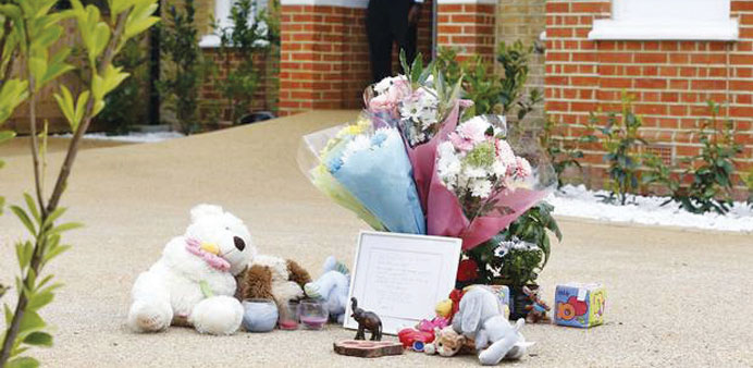Flowers and toys left outside the house.
