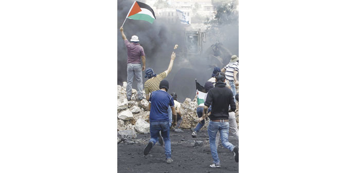 Palestinians clash with Israeli security forces following a weekly protest against the expropriation of Palestinian land by Israel in the village of K