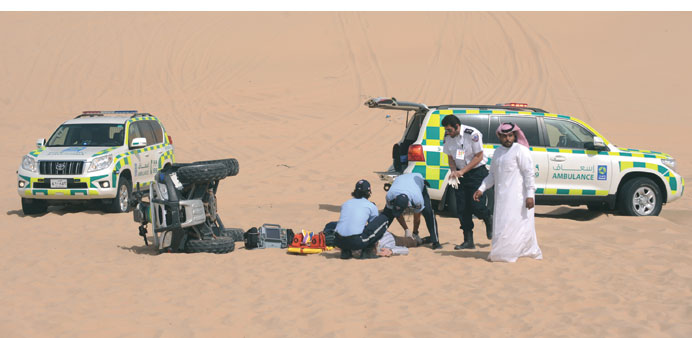The Ambulance Service paramedic staff are seen attending to the patient after receiving a call from the passer-by (standing to the right in thobe); in