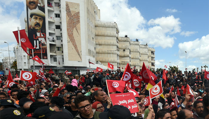 Tunisians wave their national flag during a march against extremism outside Tunis' Bardo Museum.