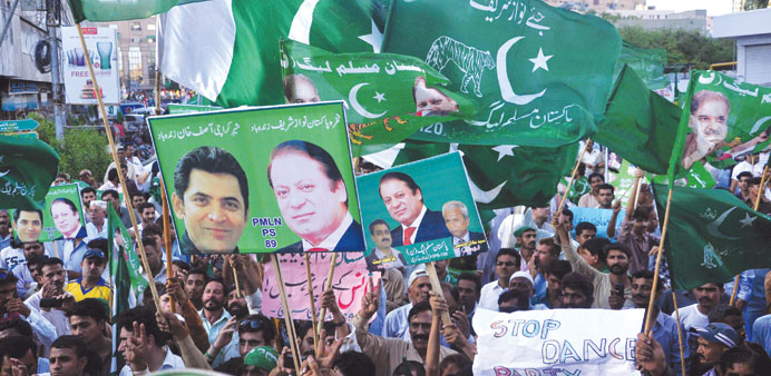 Pakistan Muslim League Nawaz supporters hold party flags and portraits of Prime Minister Nawaz Sharif during a rally in Karachi yesterday.