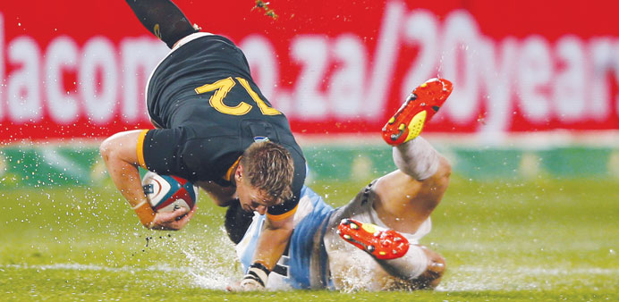 Australian Wallabies fullback Israel Folau (C) pushes away New Zealand All Blacks fly-half Aaron Cruden (R) during their rugby union Test match in Syd