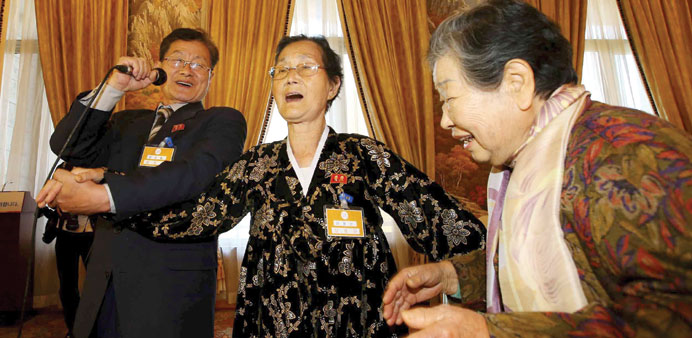 South Korean Nam Joong-nang (right) sings together with her North Korean relatives Ra Myung Seon (centre) and Nam sun Cheol at a group luncheon during