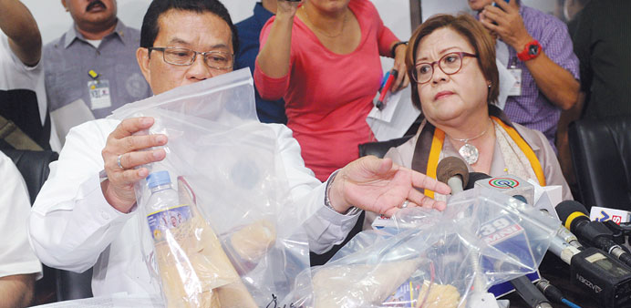 Justice Secretary Leila de Lima (right) and National Bureau of Investigation director Virgilio Mendez  display seized improvised firebombs and firearm