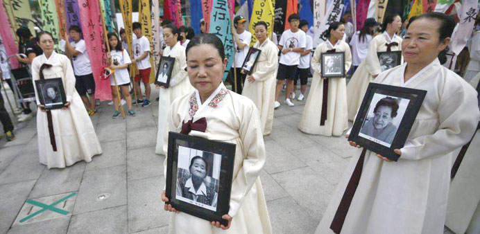 A march in Korea displays portraits of women who were made sex slaves by the Japanese military during World War II.