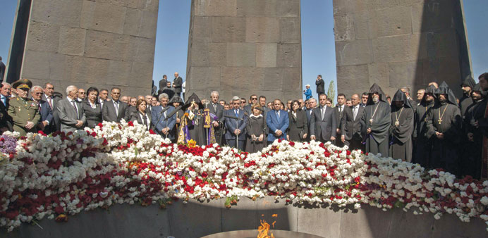 Sarkisian, Armenian Apostolic Church leader Catholicos Garegin II, and top officials hold a moment of silence after laying flowers at the monument to 