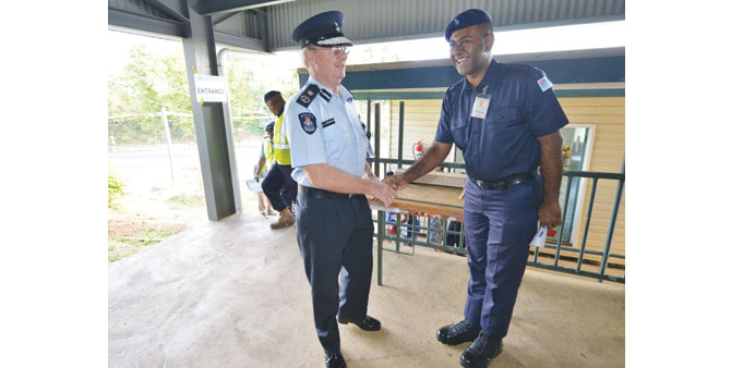 File photo shows South African-born police commissioner Ben Groenewald  (left) greeting a police officer at the voting station in Vatuwaqa Public Scho