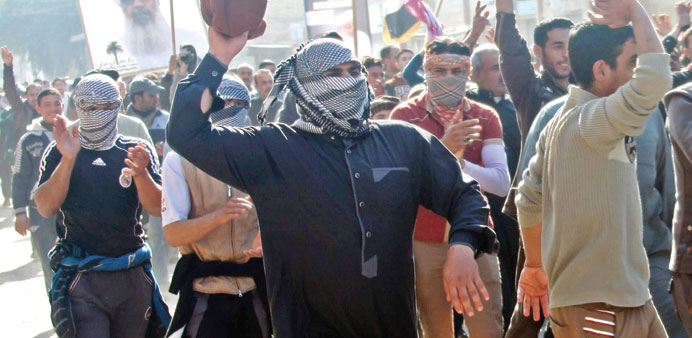People shout slogans during a protest against the arrest of Sunni lawmaker Ahmed al-Alwani in Fallujah yesterday.