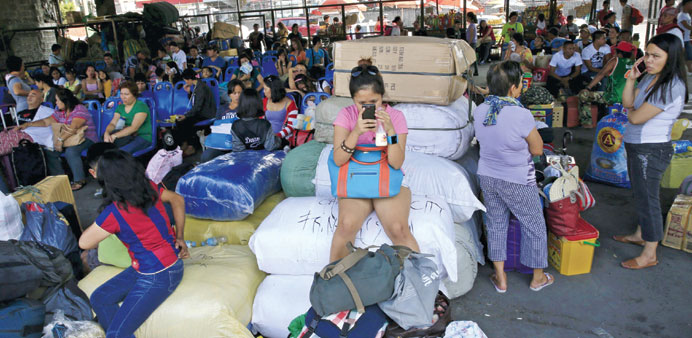 Stranded passengers guard their belongings while waiting at a bus terminal in Manila.