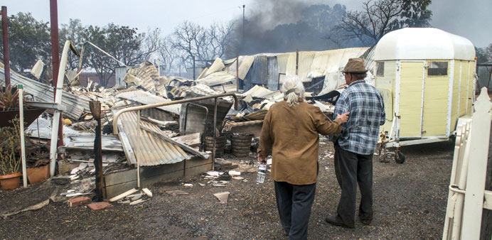 Property owners inspect their house destroyed by a bushfire near the town of Roseworthy, north of Adelaide.