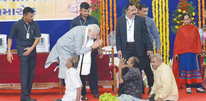 Gujarat Chief Minister and Bharatiya Janata Party (BJP) prime ministerial candidate Narendra Modi greets a group of handicapped people at the Bhadraka