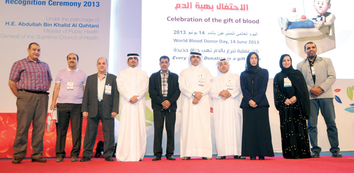 HE al-Qahtani and Dr al-Kuwari (fifth and third from right) pose for photo alongside the top seven donors including Mohamed (fourth from right) at the