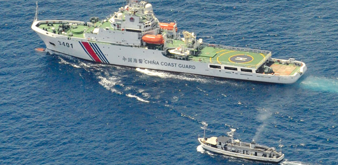 A China Coast Guard ship (top) and a Philippine supply boat engage in a standoff as the Philippine boat attempts to reach the Second Thomas Shoal, a r