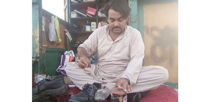 BACK TO WORK: Bashir Ahmed, a cobbler from Balochistan, is busy at his repair shop in Najma on the second day of Eid.