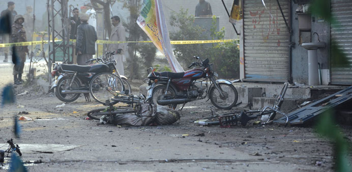 Pakistani Army soldiers and rescue officials inspect the scene of a suicide bomb attack in garrison town of Rawalpindi yesterfday.