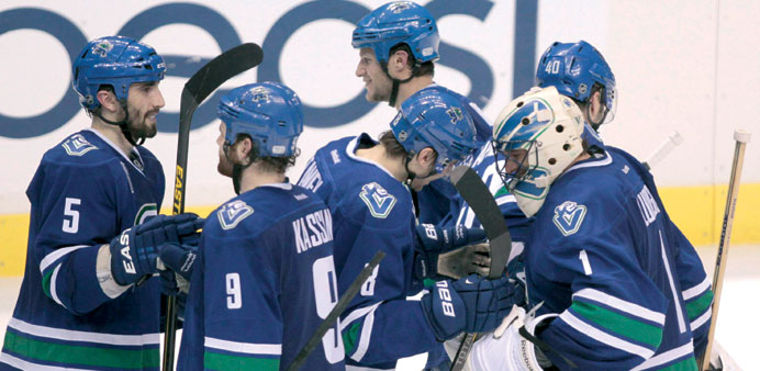 Vancouver Canucksu2019 goaltender Roberto Luongo celebrates with teammates over their shootout win against the Chicago Blackhawks in their NHL game in Van