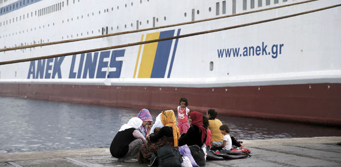 A group of Syrian women sit at the dock of the port of Kos near the ANEK Lines ship Eleftherios Venizelos.