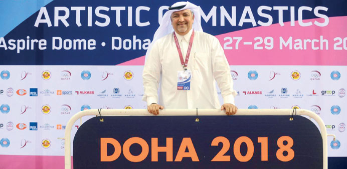 Qatar Gymnastics Federation president Ali al-Hitmi posing in front of a banner showing Doha as the candidate city for the 2018 World Artistic Gymnasti