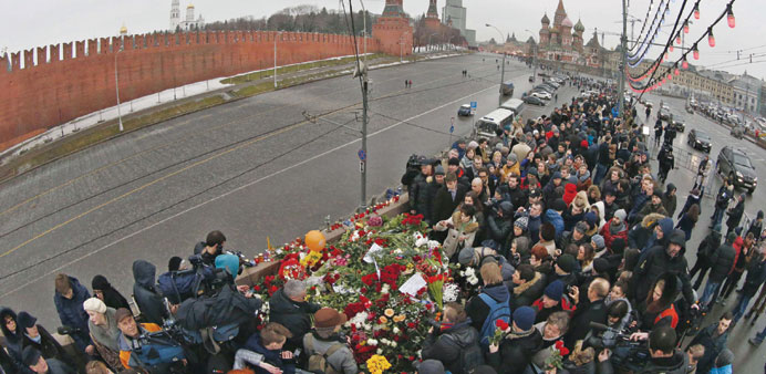 People visit the site where Nemtsov was murdered, with St Basilu2019s Cathedral and the Kremlin walls seen in the background, in central Moscow.