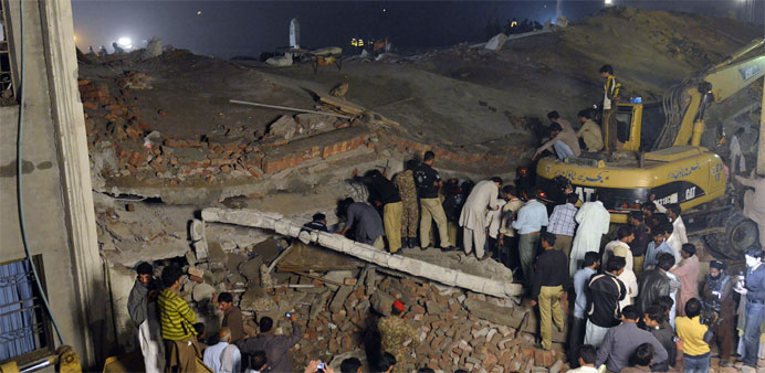 Pakistani soldiers and rescuers search the victims in the rubble of a collapsed factory on the outskirts of Lahore 