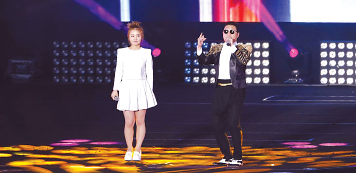 Singer Lee Hi (left) and Psy perform during Psyu2019s concert in Seoul in this file picture.