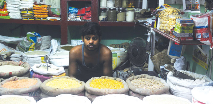 A shop-keeper waits for customers in front of rice sacks at his roadside shop in Kolkata yesterday. The Lok Sabha yesterday approved the Food Security