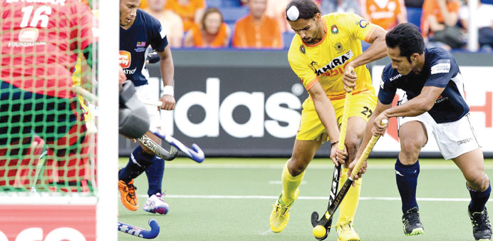 Indiau2019s Akashdeep Singh (left) attempts to score past Malaysiau2019s Tengku Ahmad during the Hockey World Cup in The Hague, The Netherlands. (AFP)
