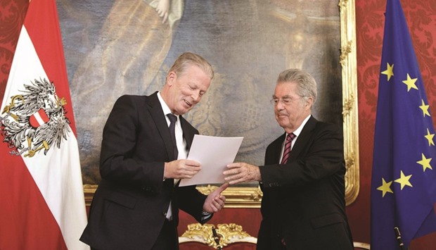 Austria President Heinz Fischer (right) entrusts Austriau2019s interim Chancellor Reinhold Mitterlehner with government functions in Vienna yesterday.