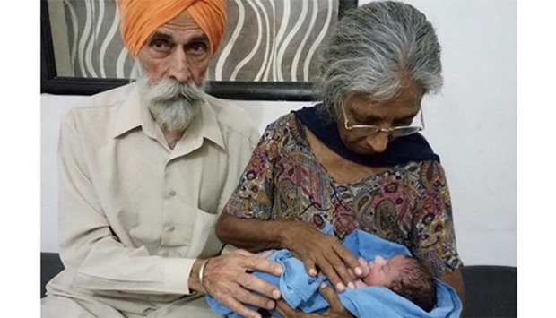 Mohinder Singh Gill(L) poses with his wife Daljinder Kaur and their newly born baby