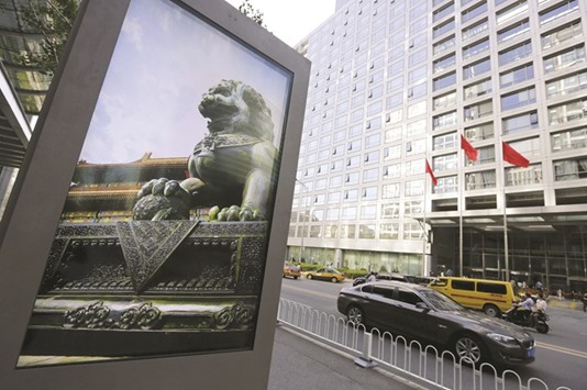 An advertising board (left) showing a Chinese stone lion is pictured near an entrance to the headquarters (right) of China Securities Regulatory Commission in Beijing. The CSRC is weighing possible restrictions on reverse mergers, including capping valuation multiples for deals involving companies that previously traded overseas.