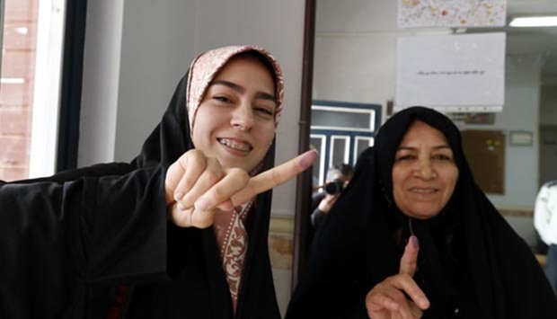 Iranian women display their fingers after casting their ballot in the elections