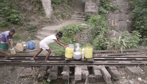 WATER STRESSED: An Indian resident uses a cart on railway tracks to move containers of drinking water after collection from a water point at Tindharia Hills some 30kms from Siliguri on April 28. The government estimates that 330 million people in India are affected by the drought.     Photo by AFP