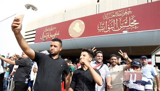 Followers of Iraq's Shia cleric Moqtada al-Sadr take selfie at the parliament building as they storm Baghdad's Green Zone after lawmakers failed to convene for a vote on overhauling the government.
