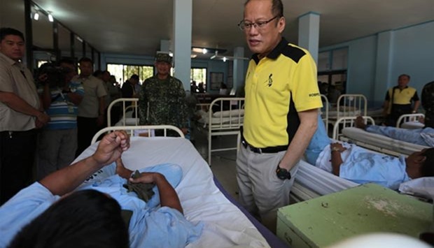 Philippine President Benigno Aquino talking to one of the wounded soldiers who recently clashed with Abu Sayyaf militants, during a visit to a military hospital in Zamboanga City on southern island of Mindanao.