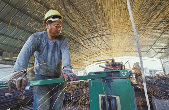 A labourer cuts steel bars at a railway bridge construction site in Lianyungang, China. Activity in Chinau2019s manufacturing sector expanded for the second month in a row in April but only marginally, an official survey showed yesterday.
