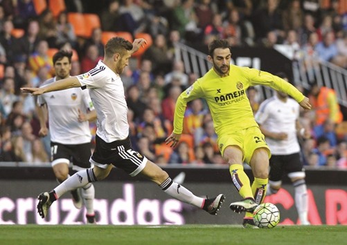 Valenciau2019s defender Shkodran Mustafi (left) vies for the ball with Villarrealu2019s Adrian Lopez during the Spanish league at the Mestalla stadium in Valencia yesterday. (AFP)