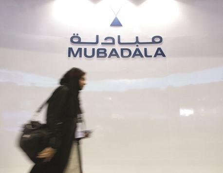 A Mubadala Development Co employee walks past the companyu2019s logo at their exhibition booth during the Singapore Airshow in this file photo dated February 20, 2008. Mubadala hasnu2019t changed its strategy amid the drop in oil, said ADS Holding chairman Mahmood al-Mahmood, who led the internal alternative investment team at the ADIA.