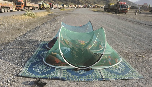 Afghan civilians sleeping along a road near the Torkham border between Afghanistan and Pakistan in Nangarhar province yesterday.