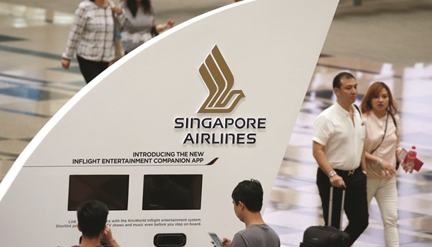 People pass a Singapore Airlines signage at Changi Airport. Shares of Southeast Asiau2019s biggest airline fell the most in almost five years last week as the carrier faces increasing challenges to retain front-end customers amid the expansion of Middle East airlines.
