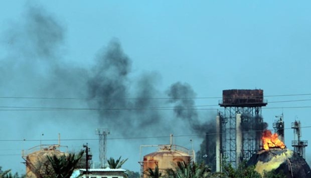 Flames and smoke rise from tanks after a suicide bomb attack on the Taji gas plant, about 20 kilometres north of Baghdad, on Sunday.