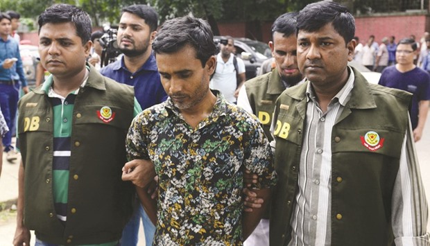 Police parading suspect Shariful Islam Shihab, centre, in Dhaka yesterday, after his arrest in connection with the murder of two gay rights activists.