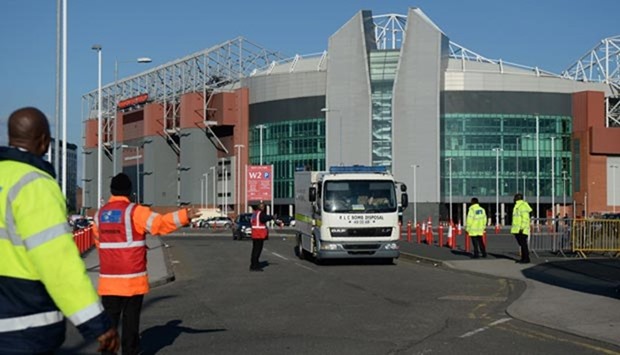 Event staff guide a British Army bomb disposal unit truck as it leaves Old Trafford stadium in Manchester, after the English Premier League football match was abandoned.