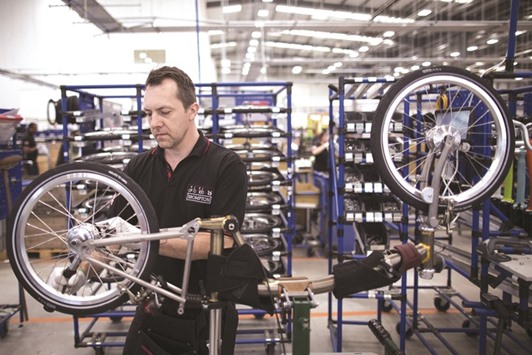 An employee fits a rear wheel on a folding bicycle in the assembly area inside the Brompton Bicycle factory in London. Britainu2019s competitiveness is being u201cundermined by our membership of a failing EUu201d and u201cBrussels red tape stiflesu201d millions of companies,  a letter signed by 300 business people, published by the Telegraph newspaper said.