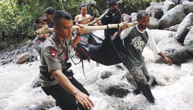 Indonesian police and villagers carry the body of a flash flood victim in Sibolangit, North Sumatra yesterday.