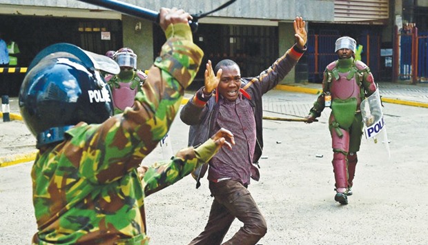 Kenyan riot police officers baton-charge an opposition demonstrator in Nairobi yesterday.