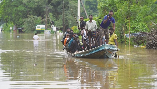 Residents using a boat to travel through floodwaters in Pugoda, near Colombo, yesterday.