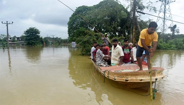 Sri Lankan residents travel by boat through the floodwaters in Pugoda, about 35 kms from Colombo, on Tuesday.