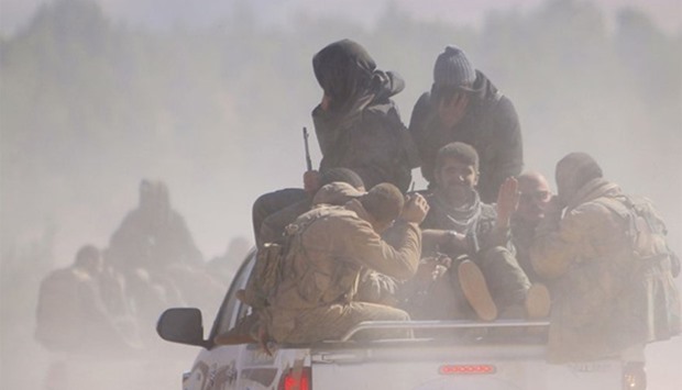 Fighters ride pick-up trucks in Syria