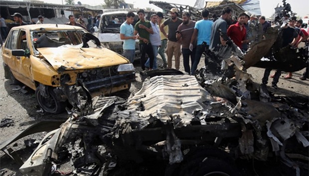 Iraqis check the damage after a suicide bomber detonated an explosives-rigged vehicle in northern Ba