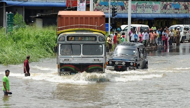 Sri Lankan commuters drive through floodwaters along an expressway in the suburb of Athurugeriya in Colombo on Wednesday.